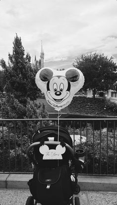 a mickey mouse balloon sitting on top of a stroller