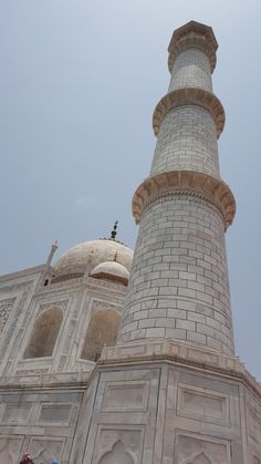 two people standing in front of a tall white building