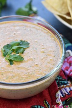 a bowl filled with white sauce and cilantro on top of a red napkin