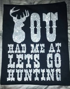 a black t - shirt with white letters and a deer's head on it