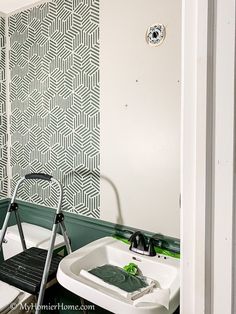 a white sink sitting under a bathroom mirror next to a wall mounted faucet