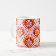 an orange and pink coffee mug with sunbursts on it's side