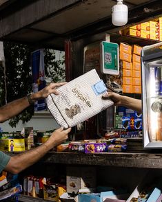 two men are handing out items to each other