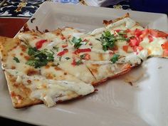 two slices of pizza on a plate with cheese and toppings, ready to be eaten