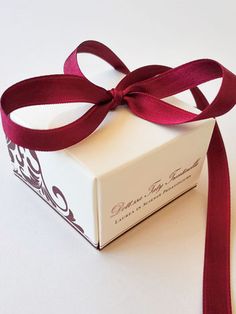 a white box with a red ribbon tied around it