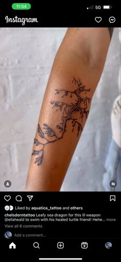 a person with a tattoo on their arm that has a tree and birds on it