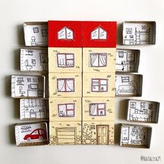 several boxes with drawings on them are arranged in the shape of small houses and a red car