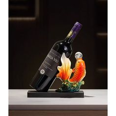 a bottle of wine and a fish figurine on a table