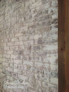 an old brick wall is painted white and brown