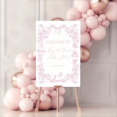 a welcome sign surrounded by pink balloons and gold foiled balloons in front of a white background