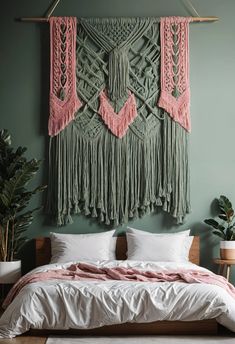 a bed with pink and green wall hangings above it