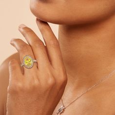 a close up of a person wearing a ring with a yellow topazte on it