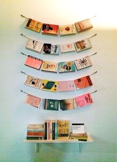 there is a book shelf with books on it and some clothes pins in the shape of a christmas tree