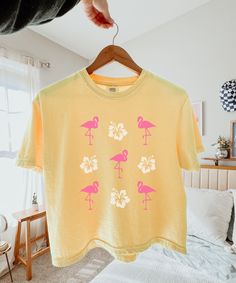 Flamingo Shirt Women Semi Cropped Tee Hibiscus Shirt Coconut Girl Beachy Shirt Flamingo Gifts Preppy Stuff Ocean Animal Shirt Teen Girl Gift An adorable flamingo and hibiscus flower semi cropped Tshirt! Printed on a Comfort Colors slightly cropped boxy fit style shirt, this new favorite is sure to be a conversation starter with other beach and animal lovers. This would also make a fun vacation shirt! Comfort Colors® is a proud member of the US Cotton Trust protocol which means this shirt is made Hawaiian Cotton Tops With Tropical Print, Cotton Hawaiian Top With Tropical Print, Cotton Tropical Hawaiian Shirt With Graphic Print, Hawaiian Cotton Tops With Print, Hawaiian Cotton Tops With Hibiscus Print, Cotton Hawaiian Tops With Hibiscus Print, Hawaiian Printed Cotton Tops, Hawaiian Style Printed Cotton Tops, Hawaiian Cotton Printed Tops