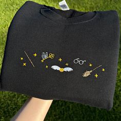 ♡ MESSAGE FOR YOU ♡ Introducing embroidered sweatshirt and embroidered shirt with embroidery on Fantasy and Magic themes. Perfect for fans of the school of magic and wizardry as a birthday gift, Christmas gift, or New Year gift. PRODUCT DETAILS We use the Gildan brand as blanks. 🔹SWEATSHIRTS: Classic fit, 50% cotton / 50% polyester, 271 GSM, fleece inside. 🔹T-SHIRTS: Classic fit, 100% cotton, 205 GSM. The white T-shirt is slightly see-through. Please check the SIZE CHART before purchasing. Uni Outfit Ideas Tshirt, Wizard Book, Tshirt Design Ideas, School Of Magic, Shirt Outfit Ideas, Magic Gift, Embroidery Sweatshirt, Embroidered Sweatshirt, Embroidered Sweatshirts