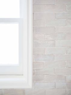 a white brick wall with a window in it