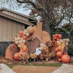 an outdoor thanksgiving decoration with balloons and pumpkins