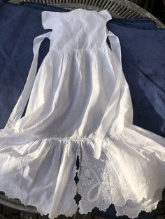 a white dress sitting on top of a blue blanket