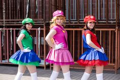 three women dressed in colorful costumes posing for the camera