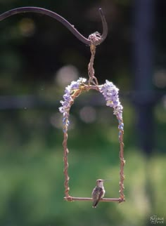 a small bird sitting on top of a metal frame