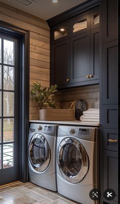 a washer and dryer in a room with dark wood paneling on the walls