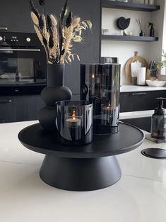 a table with candles and vases on it in the middle of a kitchen area