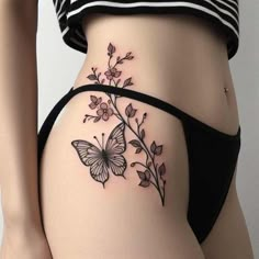 a woman's stomach with a butterfly tattoo on the side of her body and flowers