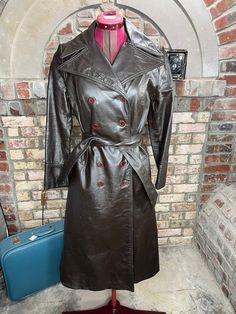 leather trench coat brown double breasted Vintage 70s  size 7 wonderful 1970s dark leather trench with exaggerated shawl collar. has some light discoloration splatter marks on the back of the sleeve and back of the skirt. fully lined. in overall stunning condition. 100% leather Be aware that vintage sizes may vary from modern standard sizes. See the sizely chart in the product photos for full measurements. The measurements are the most accurate gauge of the garments size. chest, waist and hip measurements are taken laying flat and then doubled. all measurements are approximate.  Vintage items are carefully inspected and I do my best to describe all flaws. but all vintage items may have unnoticed flaws and signs of wear from being preloved. Full measurements are listed so we do not accept r Fall Vintage Fashion Single-breasted Outerwear, Fitted Brown Belted Outerwear, Retro Brown Double-breasted Outerwear, Vintage Brown Outerwear With Double Button Closure, Vintage Double-breasted Outerwear For Fall, Fitted Vintage Double-breasted Outerwear, Brown Vintage Outerwear For Fall, Brown Outerwear For Fall Vintage Fashion, Retro Fitted Long Coat