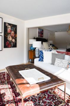 a living room filled with lots of furniture and pictures on the wall above it's coffee table