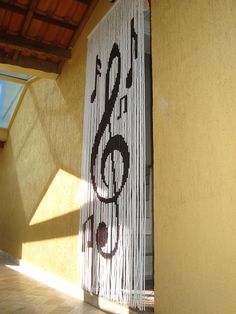 a music note on the side of a building next to a window with sunlight streaming through it