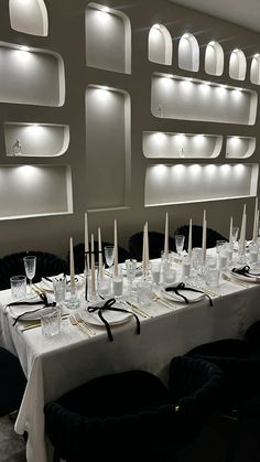 a long table is set up with place settings and candles for dinner guests to enjoy