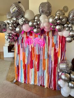 balloons and streamers decorate the backdrop for a birthday party