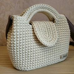 a white purse sitting on top of a wooden table