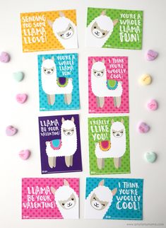 four llama valentine's cards on a white surface with candy hearts around them