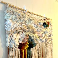 a wall hanging made out of yarn and beads