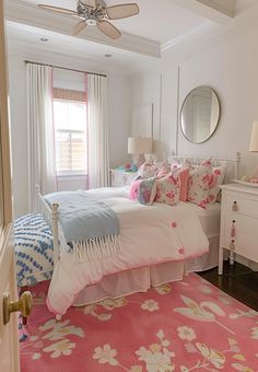 a bed room with a neatly made bed next to a window and a ceiling fan