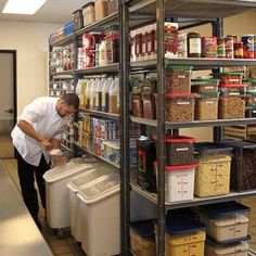 a man standing in front of a shelf filled with lots of food and containers next to bins