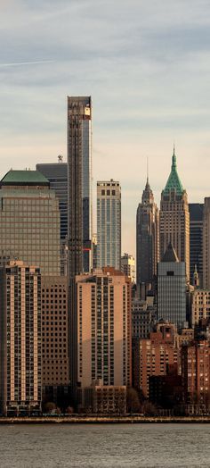 the city skyline is seen from across the water, with tall buildings in the foreground