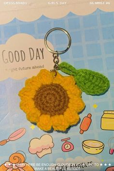 a crocheted sunflower keychain with a good day tag on it