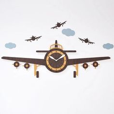 a clock that is on the side of a wall with airplanes flying in the sky