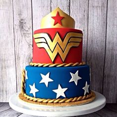 the cake is decorated like wonder woman's symbol with stars on it and gold crown