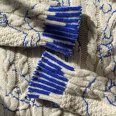 two blue and white knitted combs laying on top of each other in the same pattern