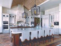 a large kitchen with an island in the middle and lots of cabinets on both sides