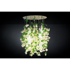 a chandelier with white flowers hanging from it's sides on a black background