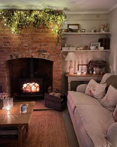 a living room filled with furniture and a fire place next to a brick wall covered in greenery