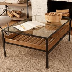 a coffee table with a book on it in front of a fire place and fireplace