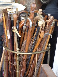 a basket filled with lots of different types of wooden canes and other woodworking tools