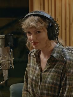 a woman wearing headphones sitting in front of a microphone