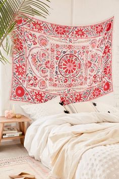 a large red and white tapestry hanging over a bed