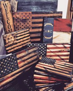 several wooden american flags are stacked on top of each other in this pile, with the words welcome to america written on them